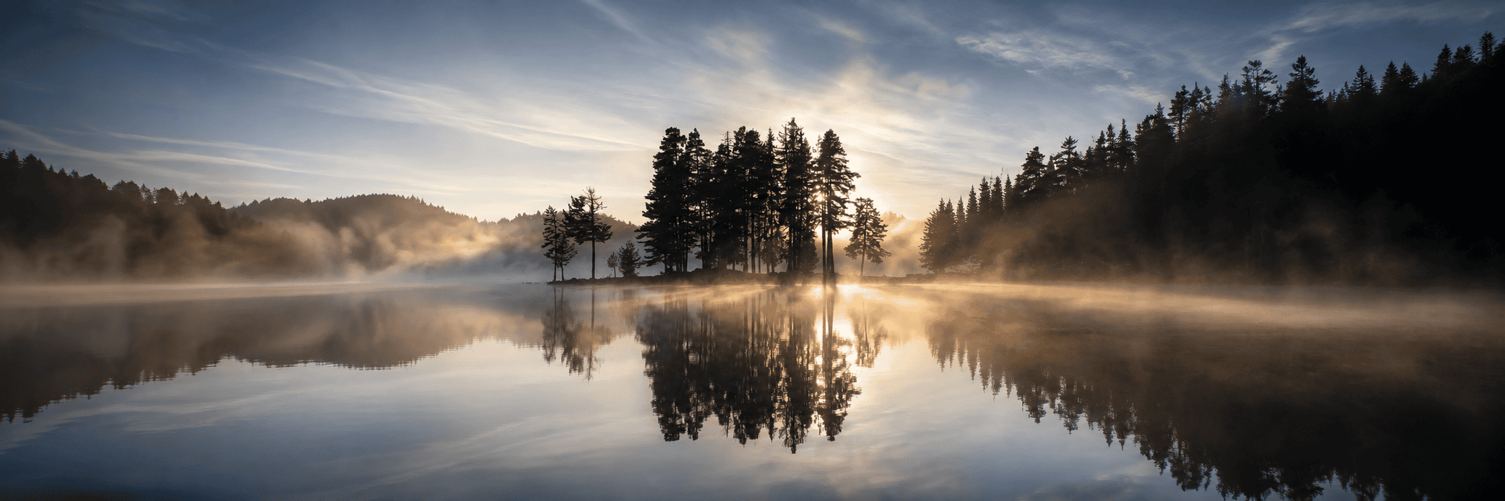 Paysage brumeux au lever du soleil, reflet sur l'eau